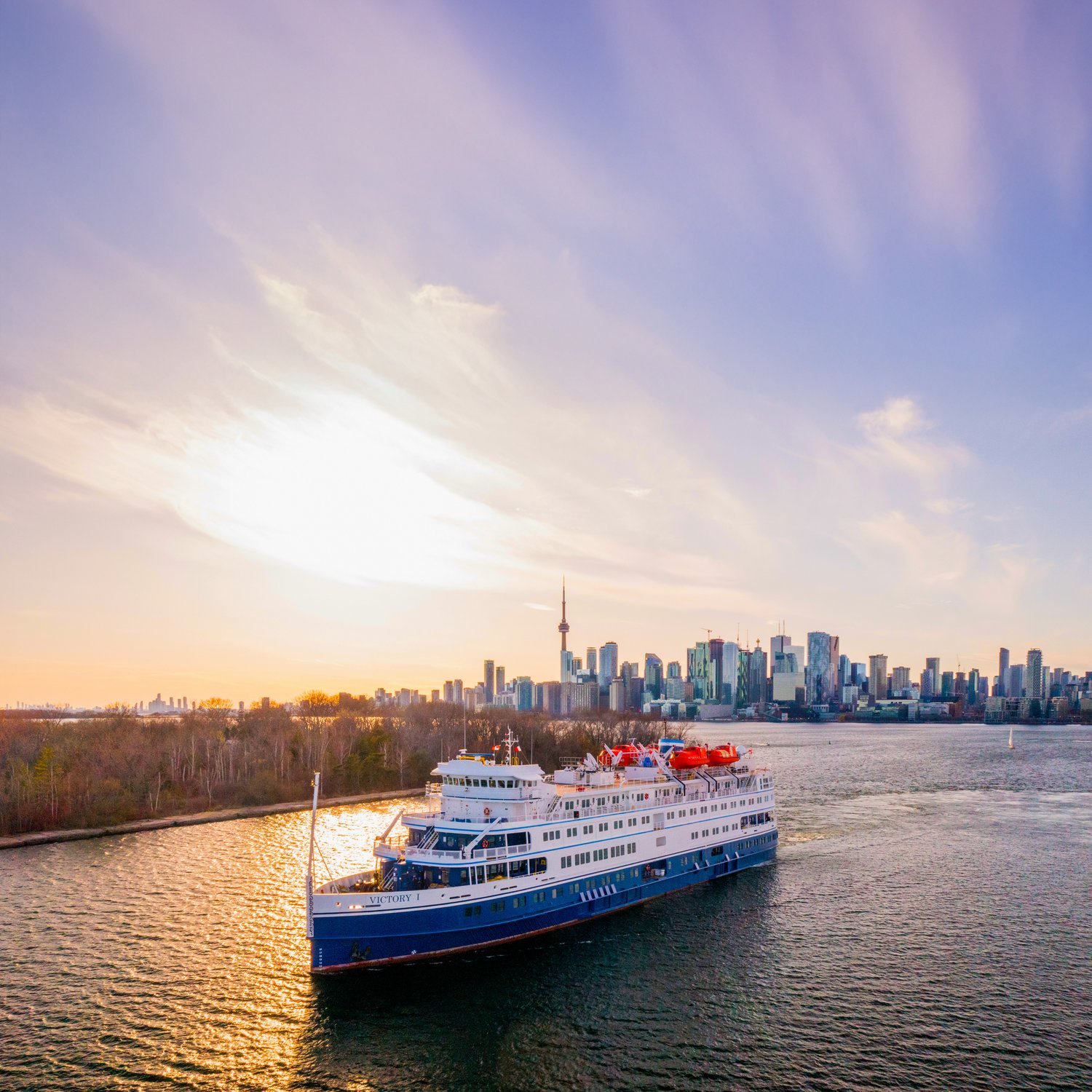 Victory I sails past the Toronto skyline at sunset