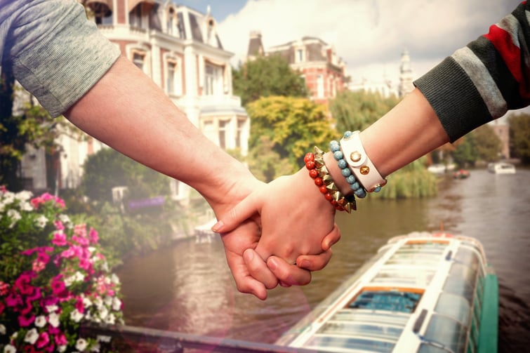 Students holding hands against canal in amsterdam