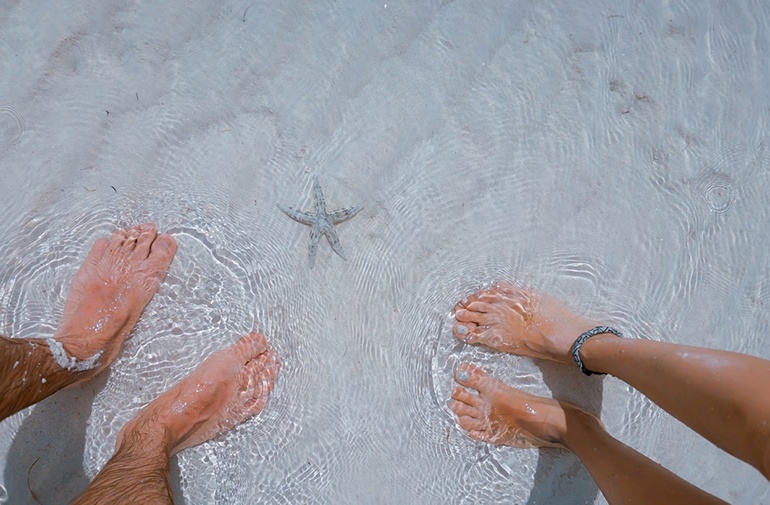 Feet in shallow water at beach